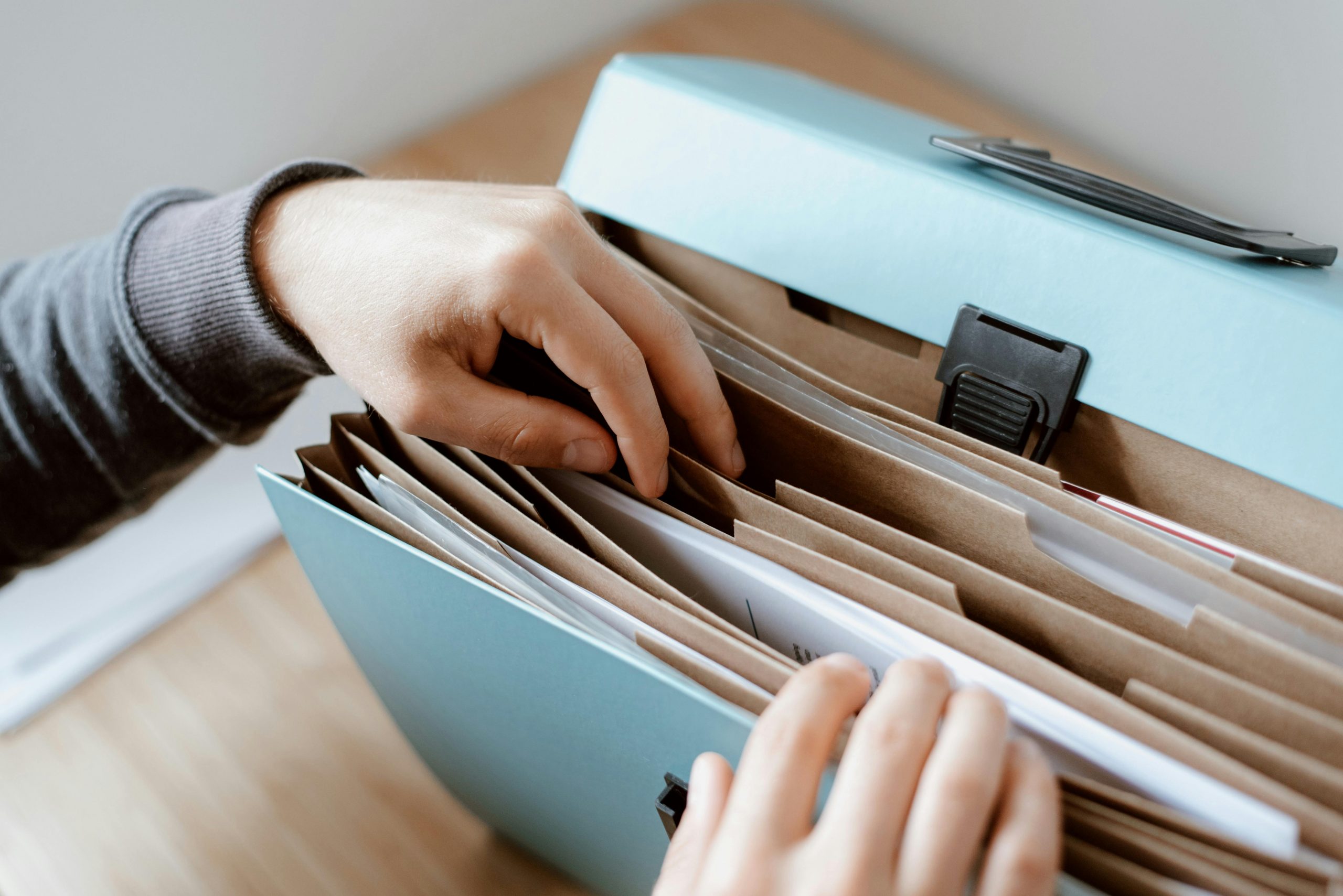 person flipping through documents in a binder