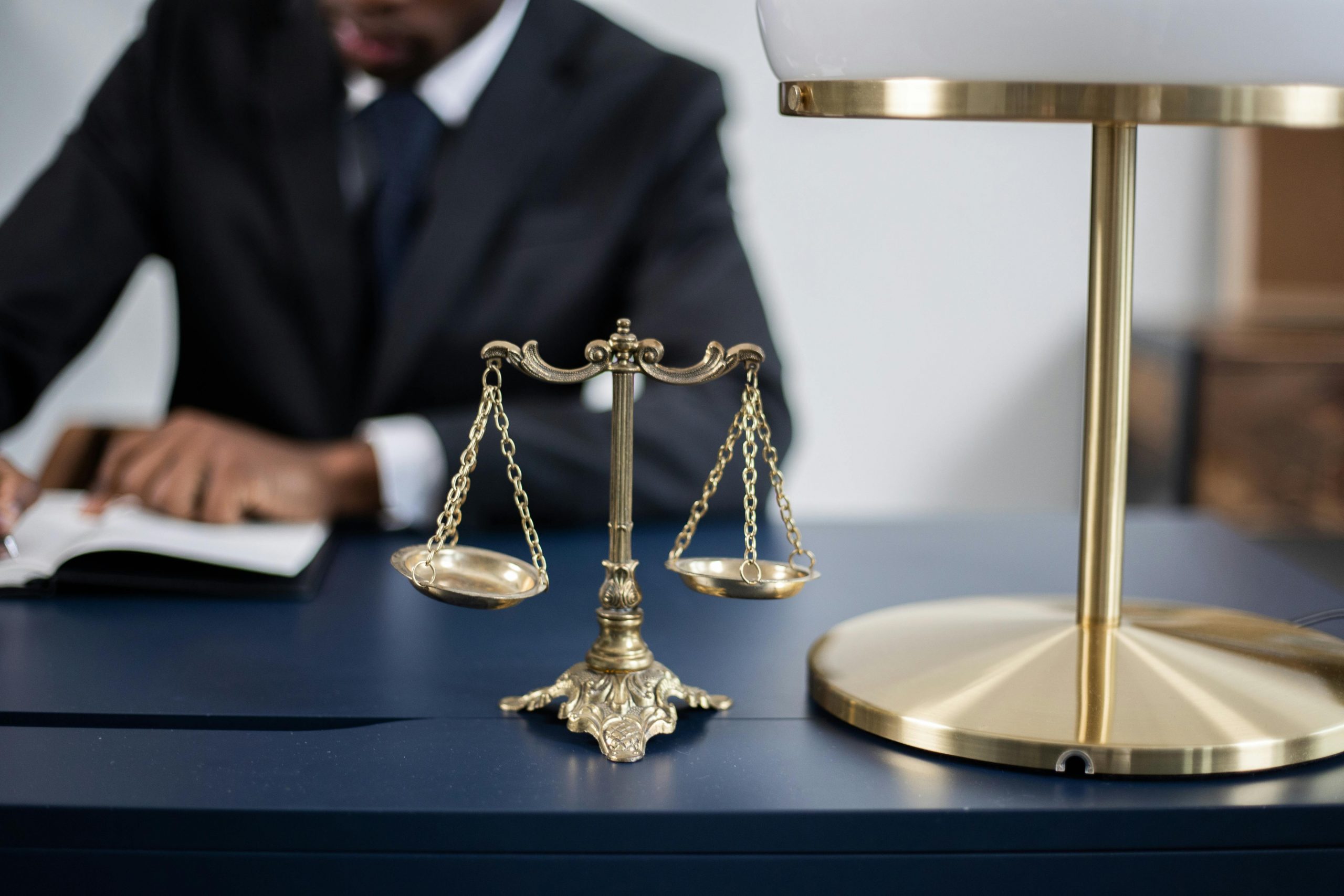 lawyer working at a desk with a balance scale figurine