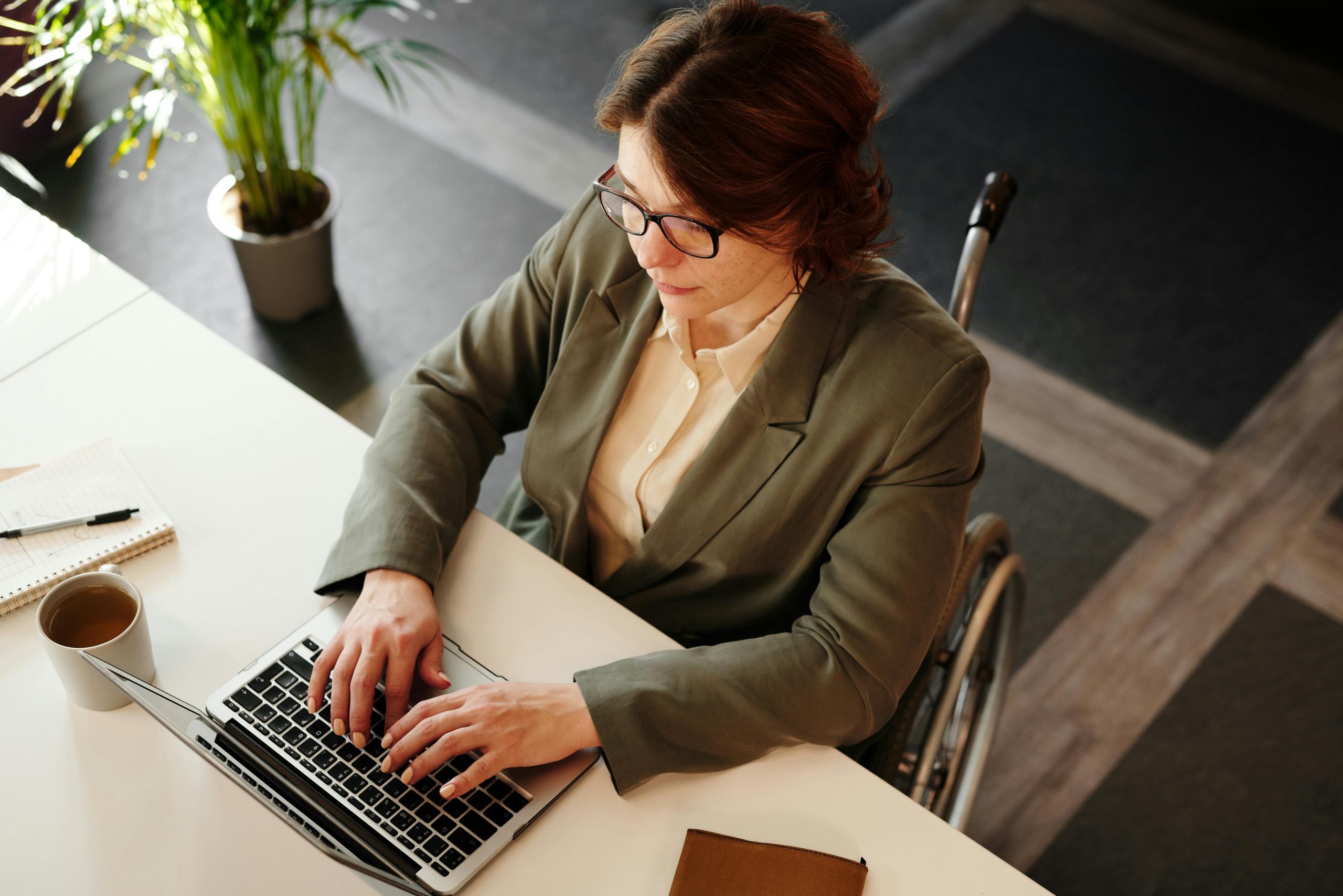 woman in a wheelchair typing on a laptop